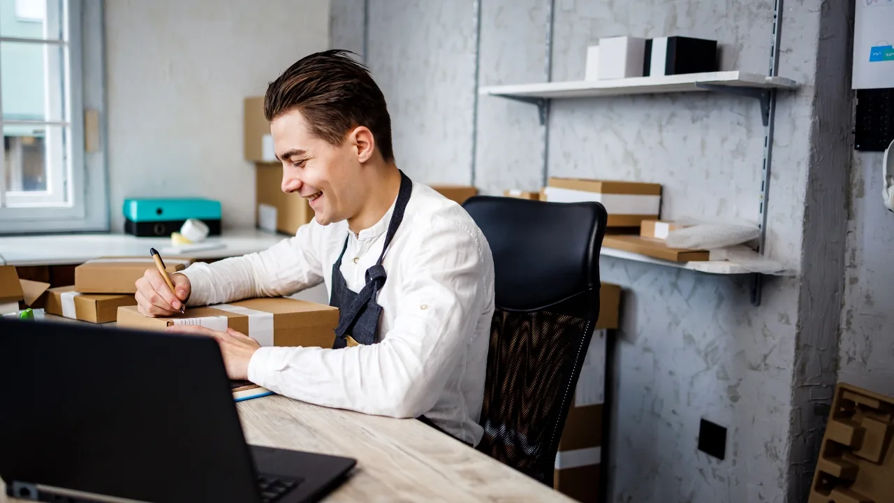Homme travaillant sur un ordinateur portable à son bureau, en train d’écrire ou de planifier