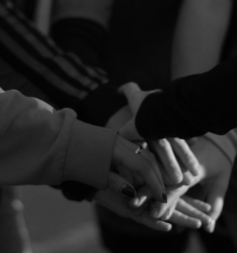 Multiple hands stacked together symbolizing unity and teamwork.