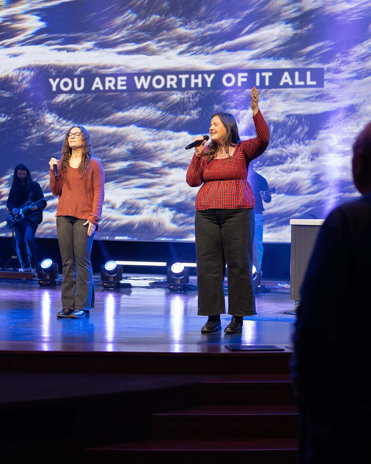 People of multiple generations worshipping together.