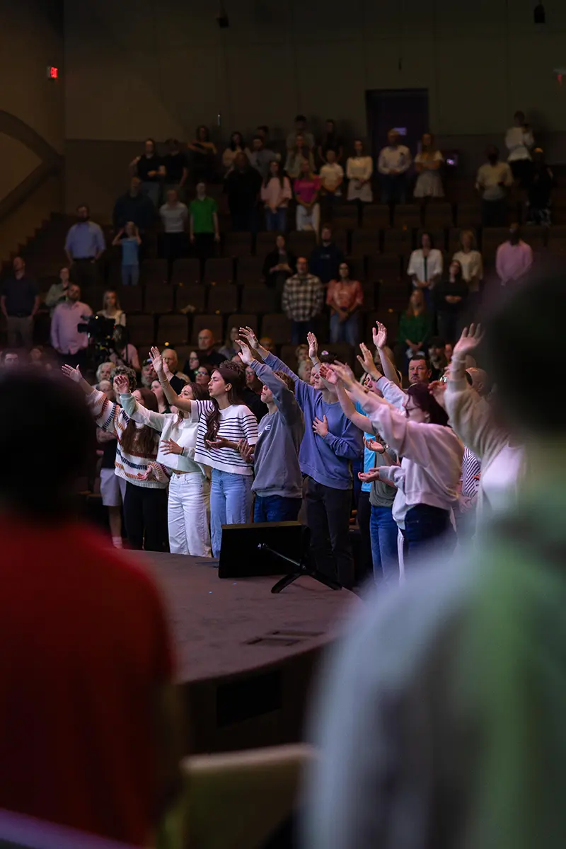 People of multiple generations worshipping together.