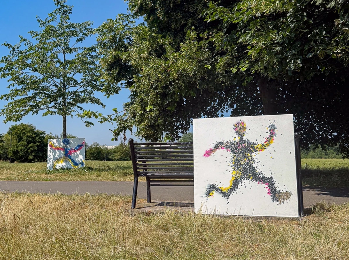 A vibrant human figure made from coloured recycled plastic granules, pressed into a solid white KRUSHED architectural panel by Revive Innovations.