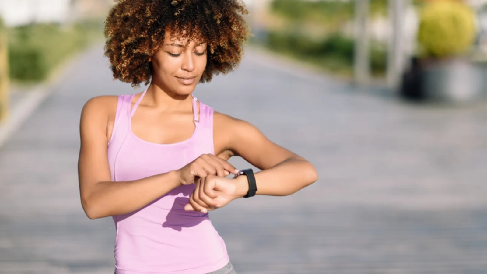 Sportive qui vérifie ses données sur sa montre connectée avant de courir