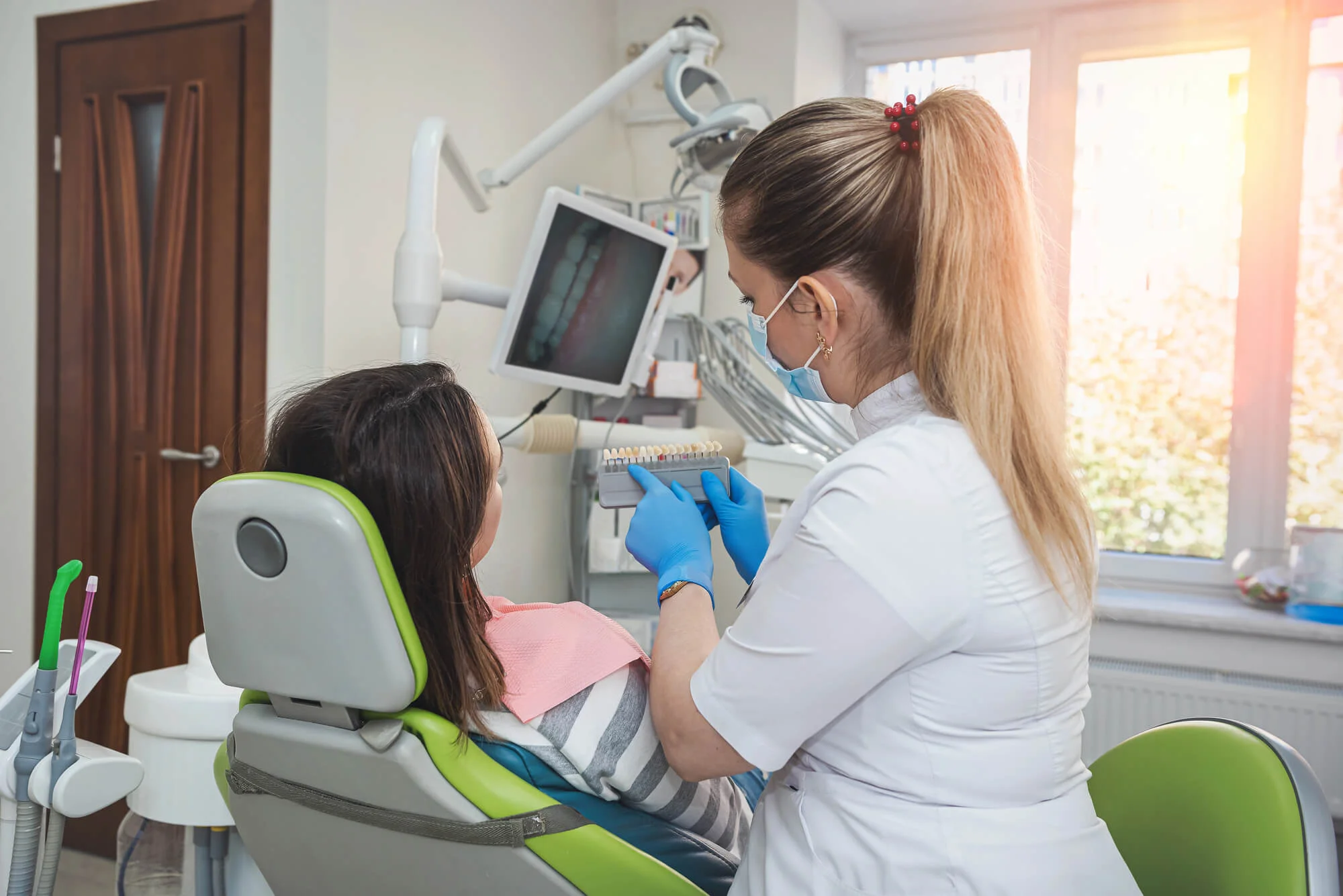Female dentist in Clarksville, TN, showing patient a tooth shade guide