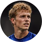 Close-up of a young man with curly blond hair wearing a blue shirt looking to the right.