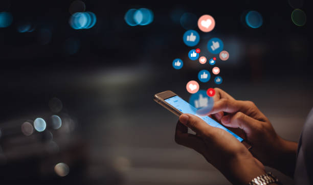 person holding phone with social media icons coming out the screen