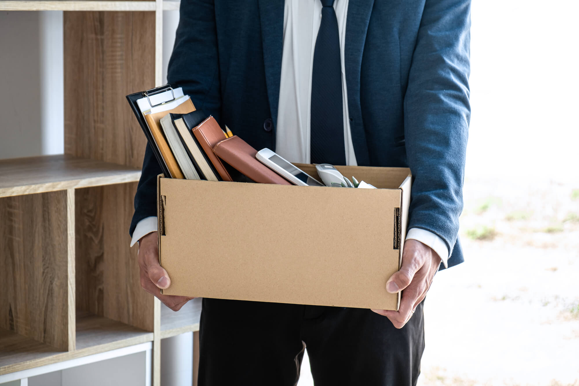 businessman carrying a box full of his personal things