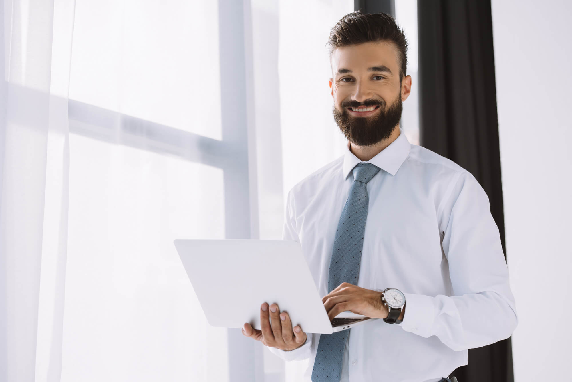 happy businessman holding laptop