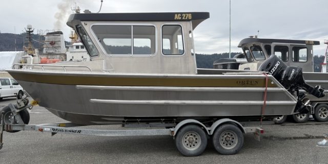 Ortun AC276 aluminum boat on a trailer at the marina with a Suzuki outboard motor.