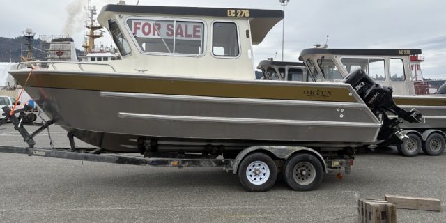 Ortun EC276 aluminum boat with a For Sale sign in the window, docked at the marina.