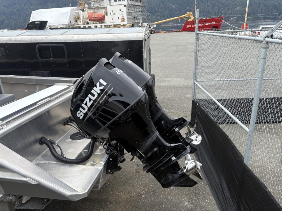 Close-up of a black Suzuki outboard motor mounted on a boat trailer.