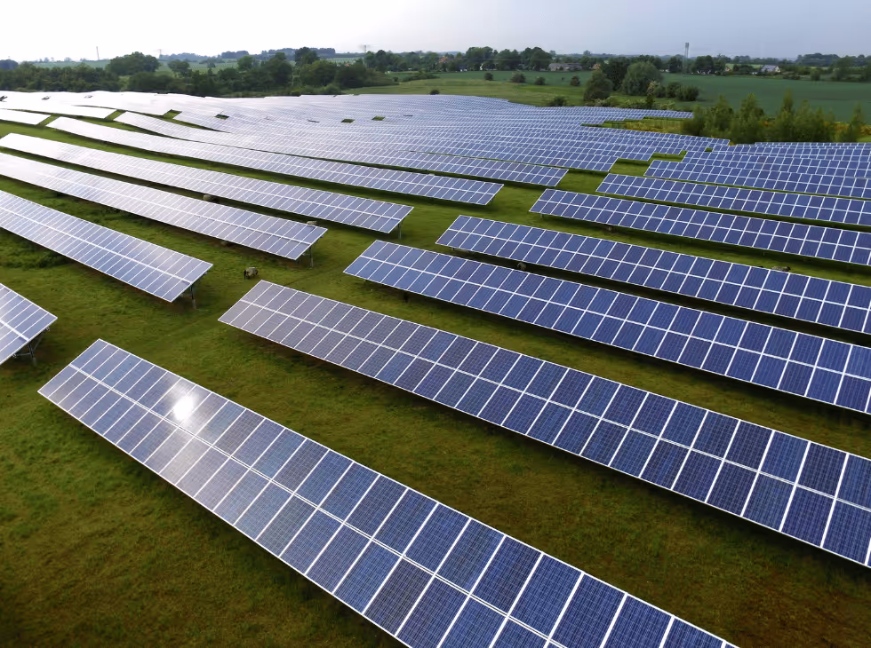 a person working on a solar panel with a blue sky in the background