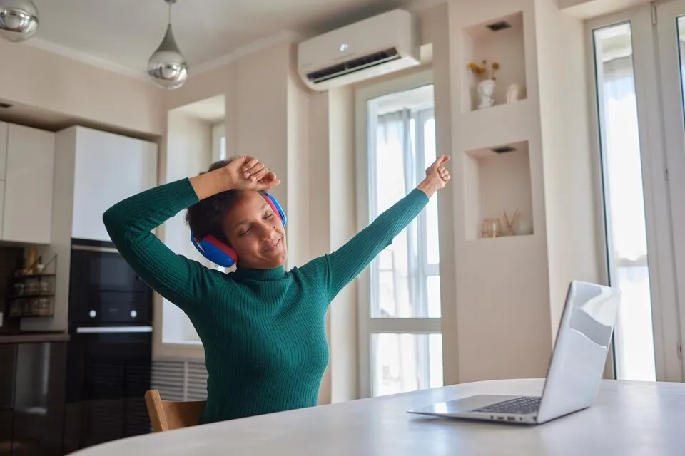 A women enjoying a cool air from an AC and stretching her body