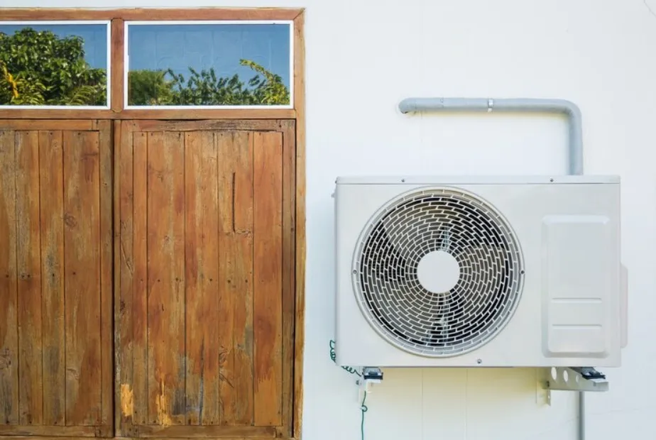 An outdoor mini split unit placed in the white wall