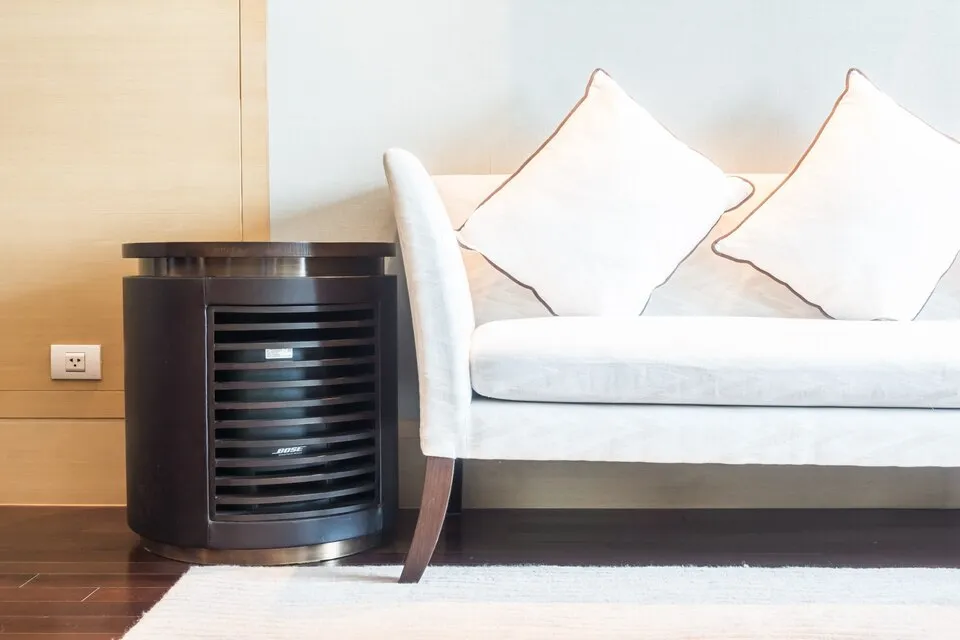 An evaporator cooler placed beside a sofa