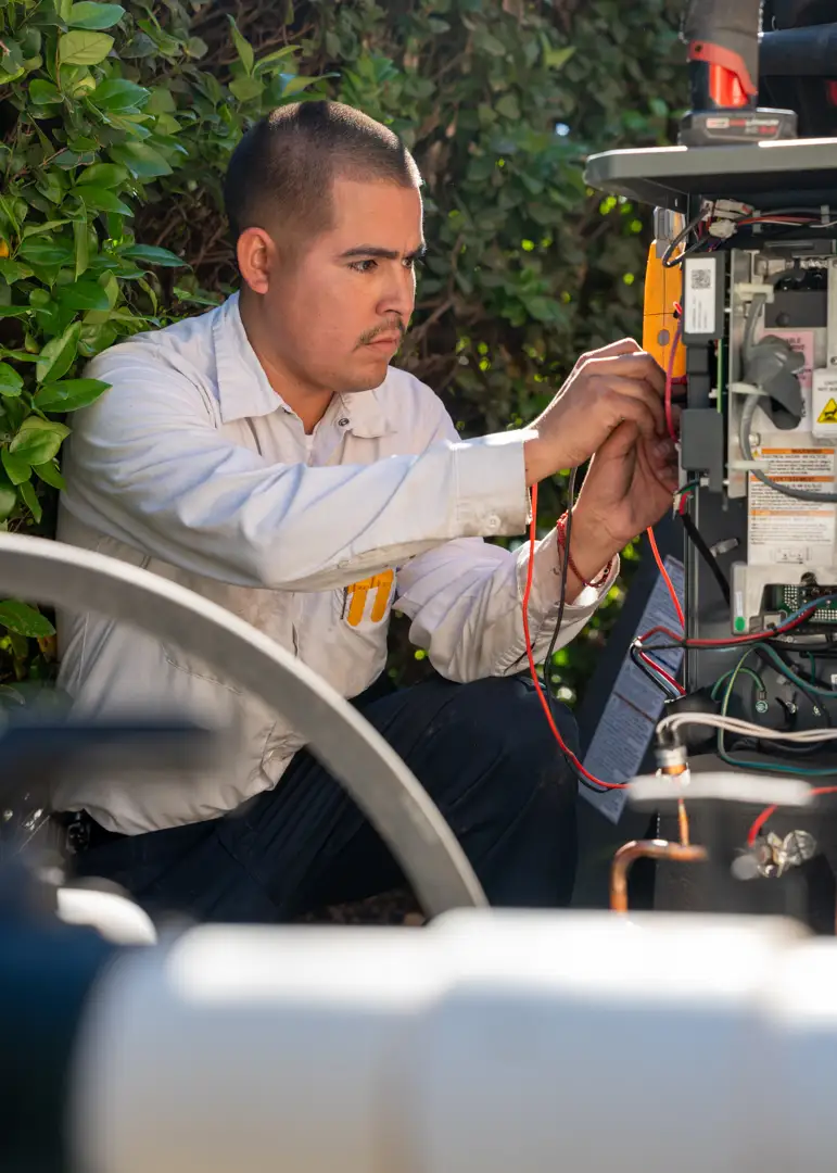 HVAC technician inspecting electrical connections HVAC technician inspecting electrical connections
