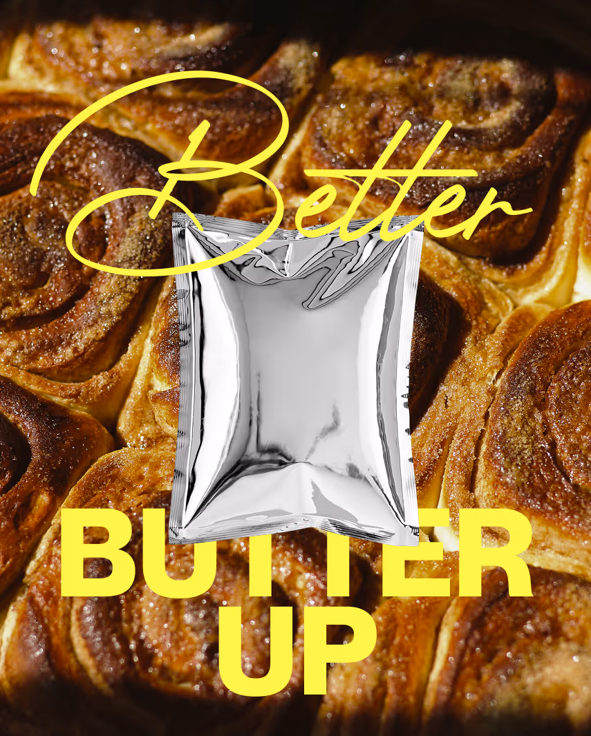 Silberne Verpackung mit dem Text ‚Gooles Butter Up‘ vor einem Hintergrund aus Zimtschnecken.