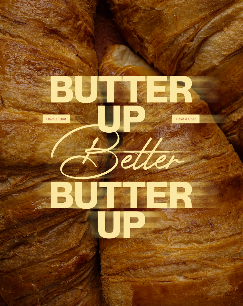 Nahaufnahme mehrerer goldbrauner Croissants mit dem Text 'Butter up Gooles Butter up' in gelber Schrift darüber.