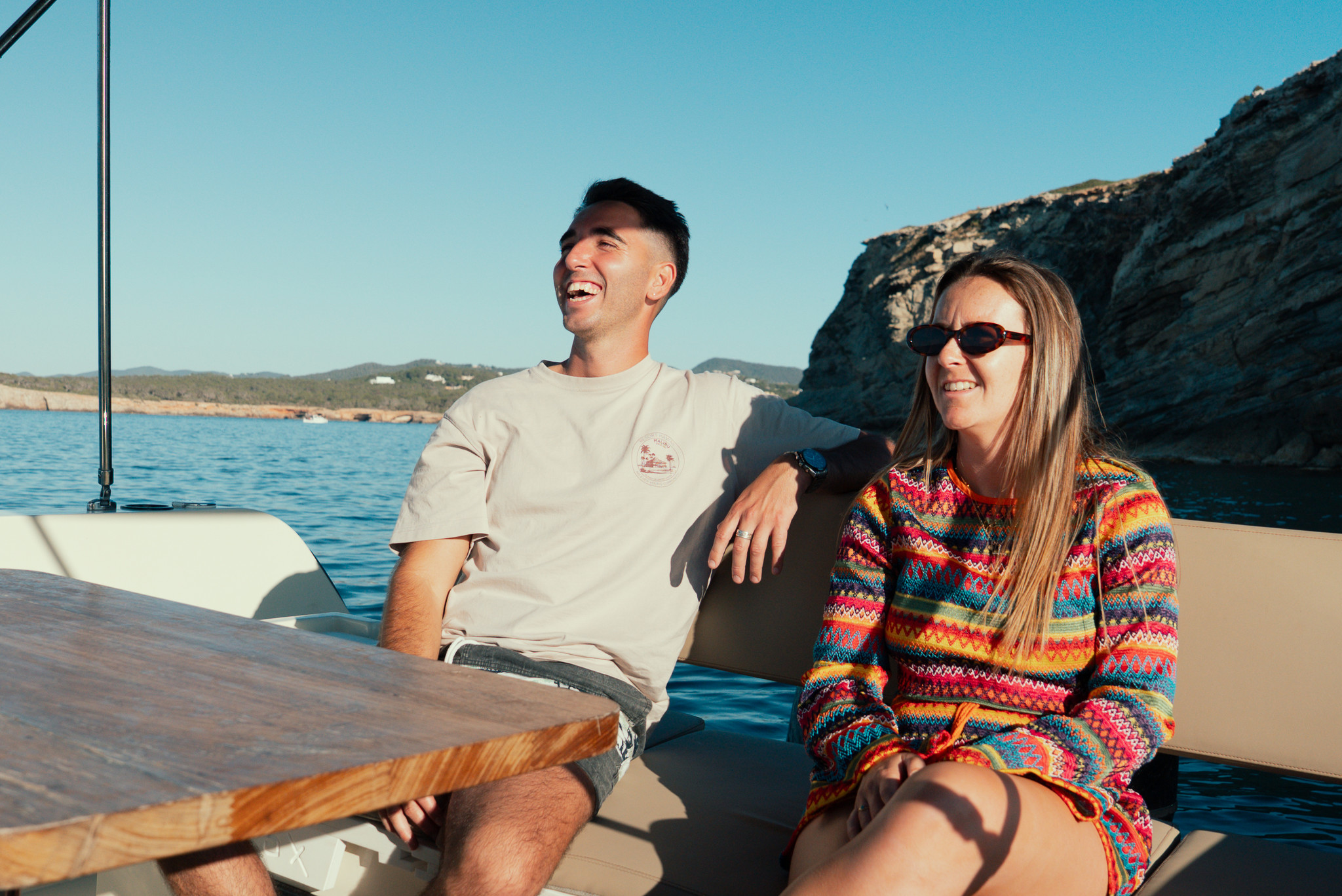 Group of people jumping off a boat into the clear blue sea, creating a splash of water, enjoying a sunny day on a tropical adventure. Fun water activities, boat ride, and summer vacation.