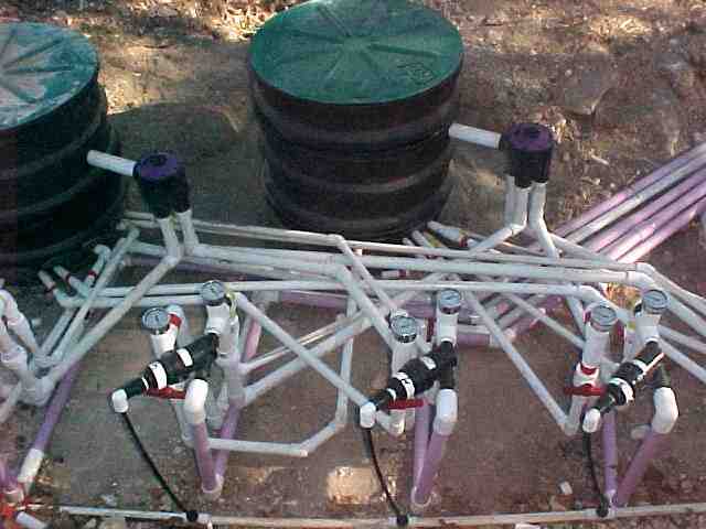 technician inspecting a drip irrigation control valve in a residential garden - drip irrigation benefits for challenging technician inspecting a drip irrigation control valve in a residential garden - drip irrigation benefits for challenging