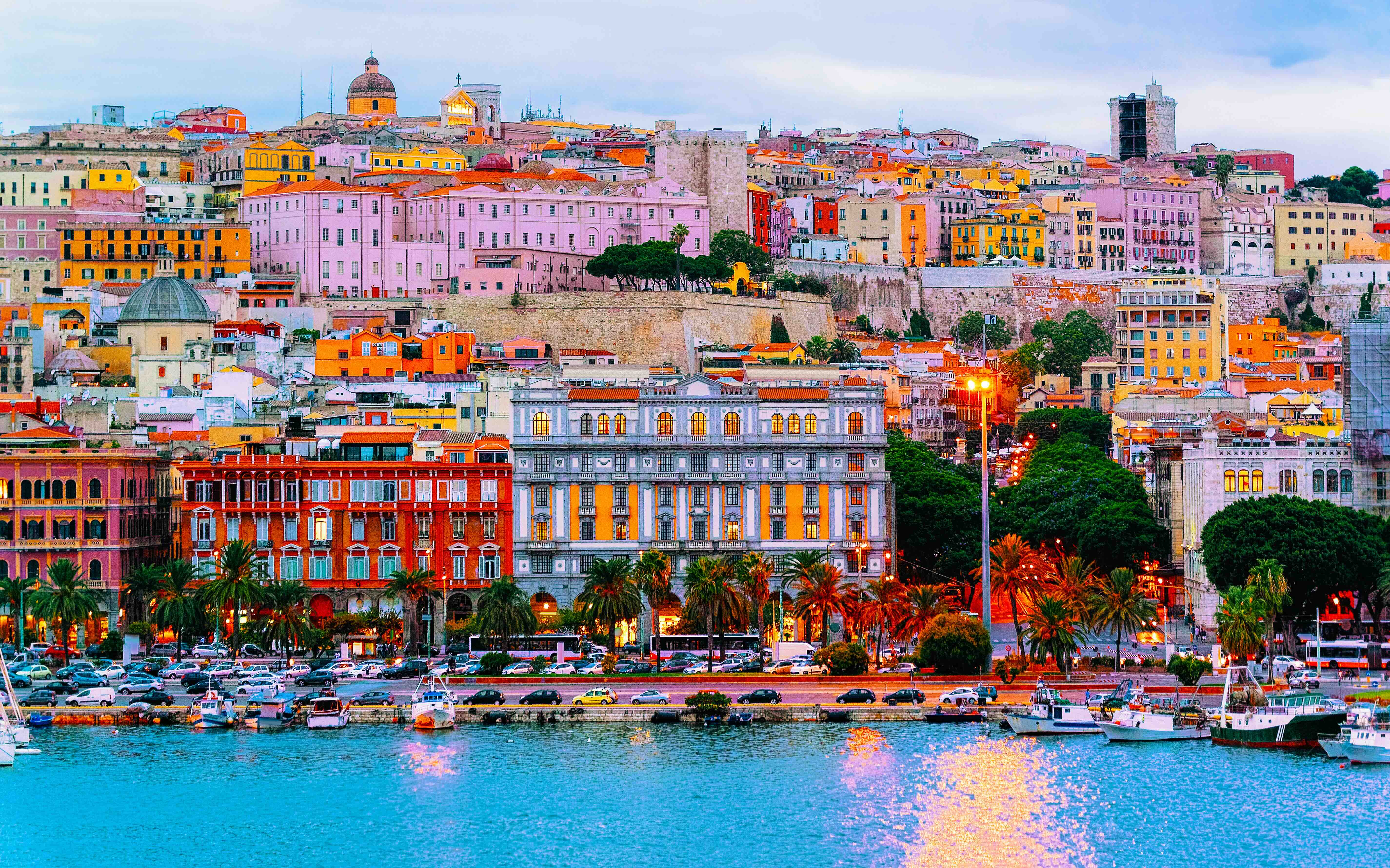 Old Sardinian Port with ships at Mediterranean Sea and city of Cagliari, South Sardinia Island in Italy