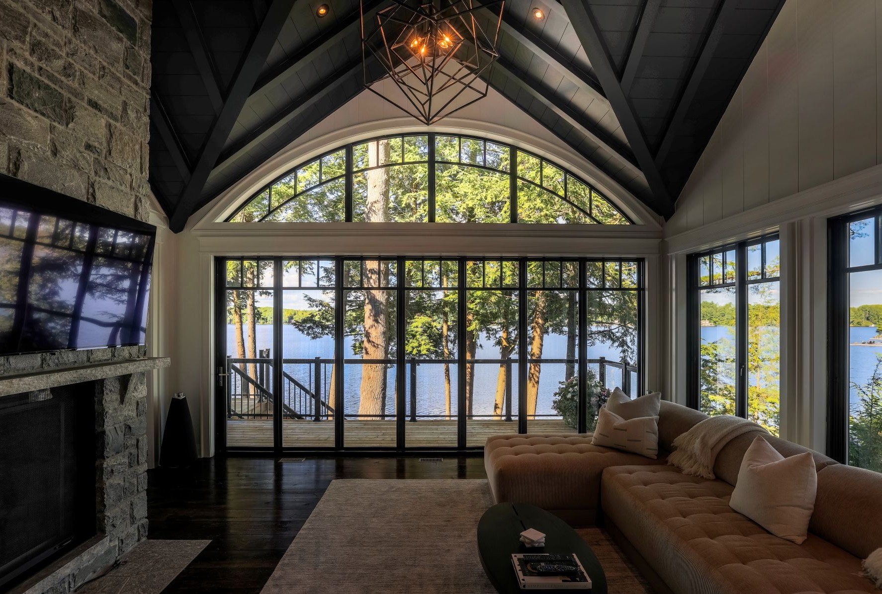 large arched window above a window wall in a living room
