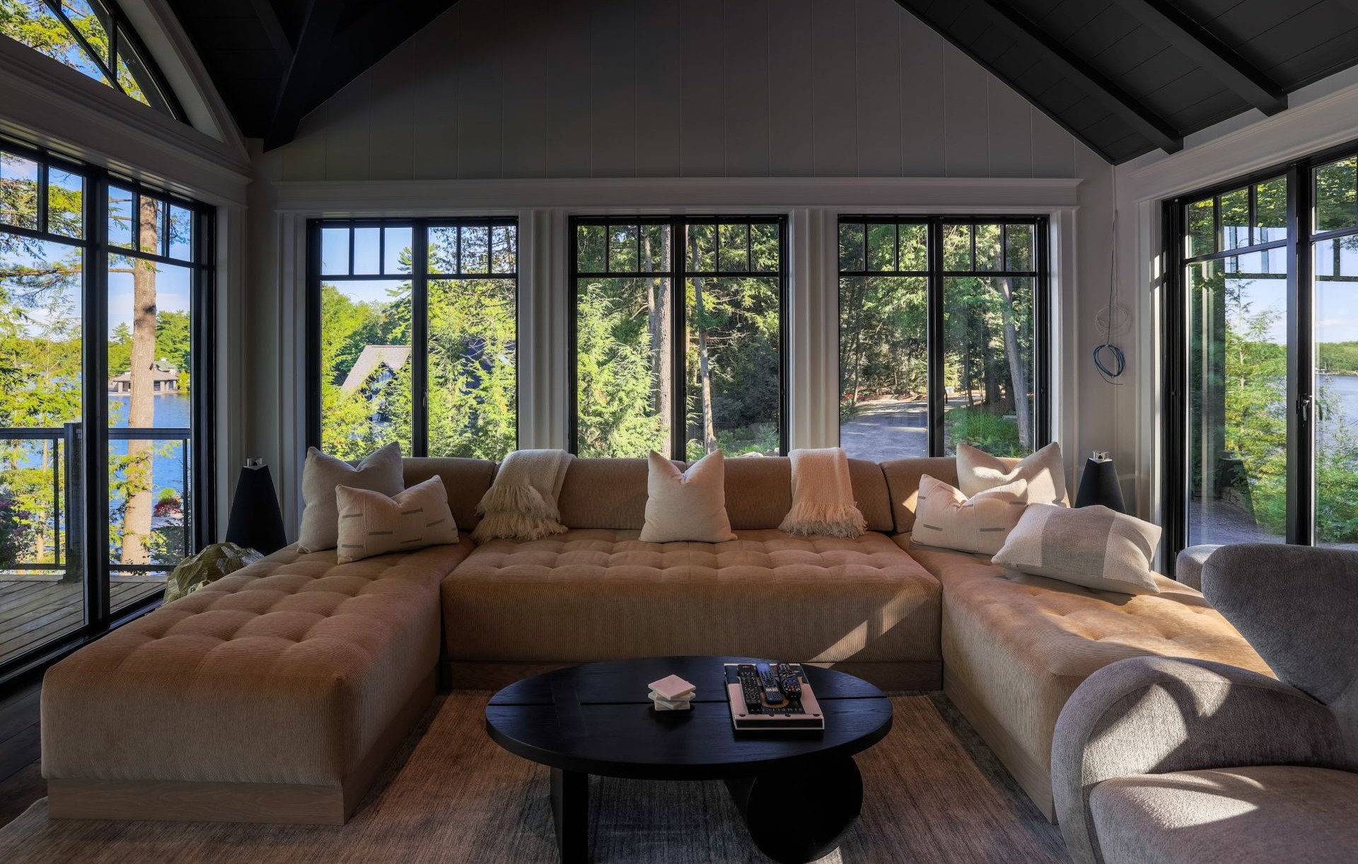 large living room with multiple black windows and patio doors
