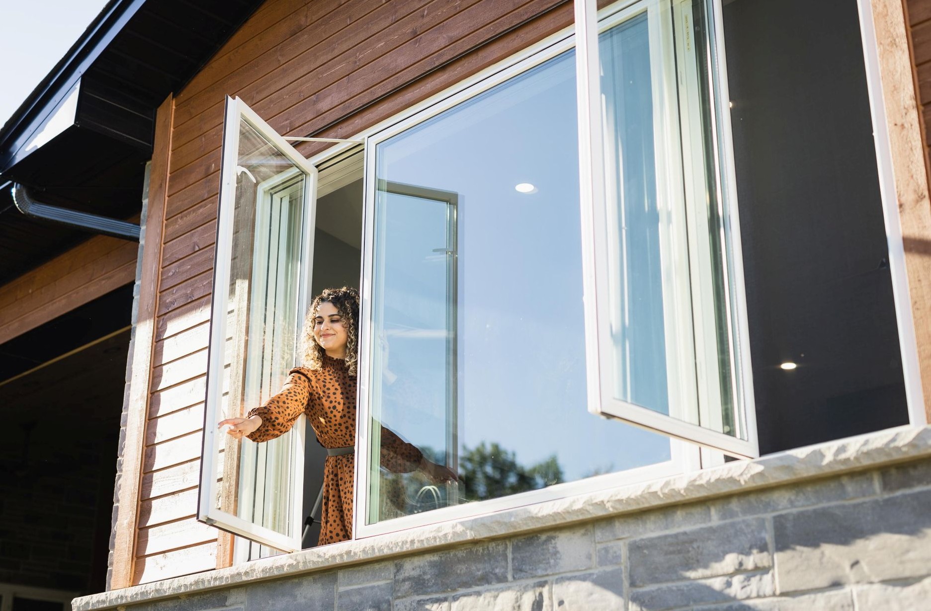 woman opening a casement window with weep holes