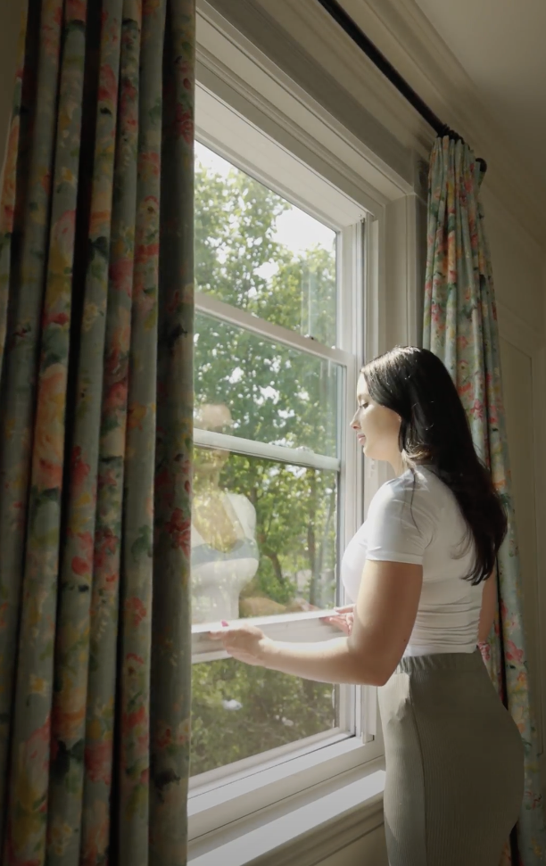 woman opening a hung window in bedroom