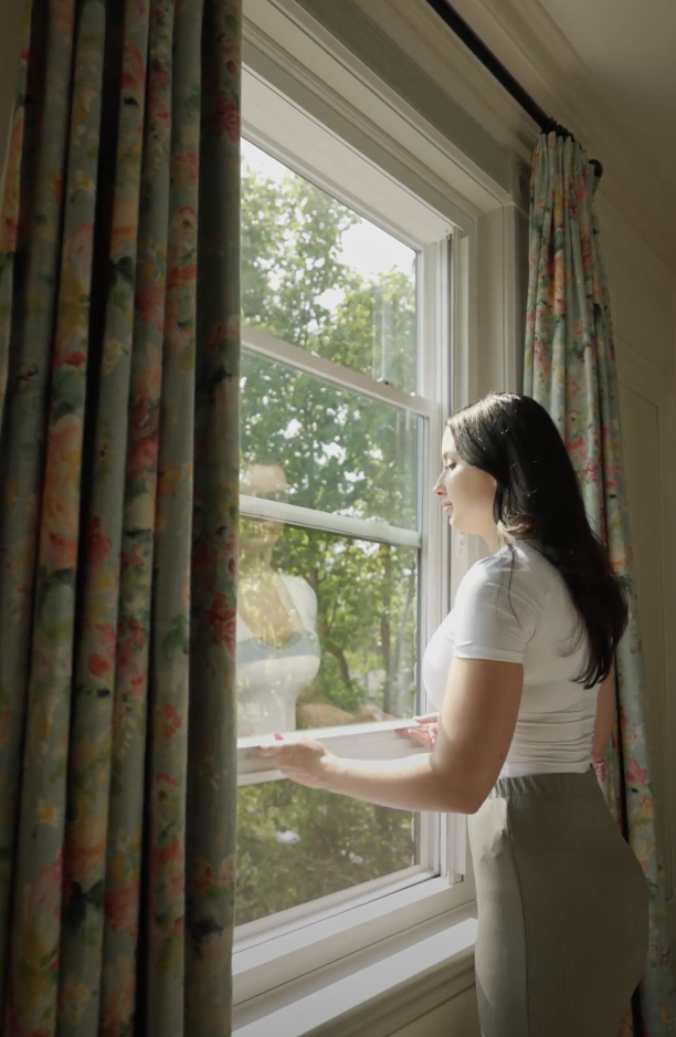 woman opening double-hung window