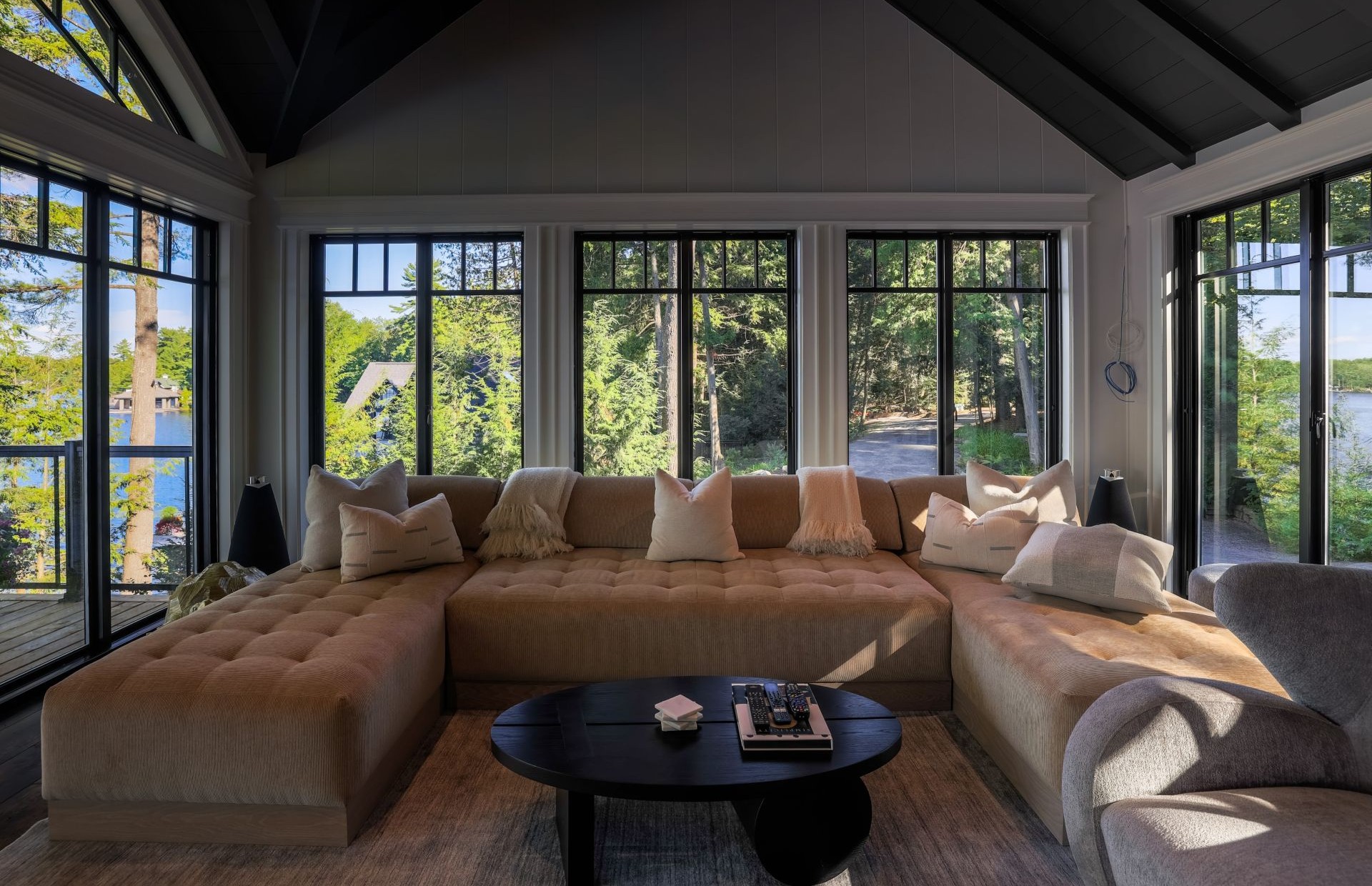large living room with couch in the middle surrounded by large windows