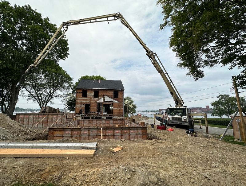 A concrete pump truck placing a foundation on a waterfront construction site