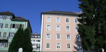 Immeuble rose à côté d'un immeuble vert