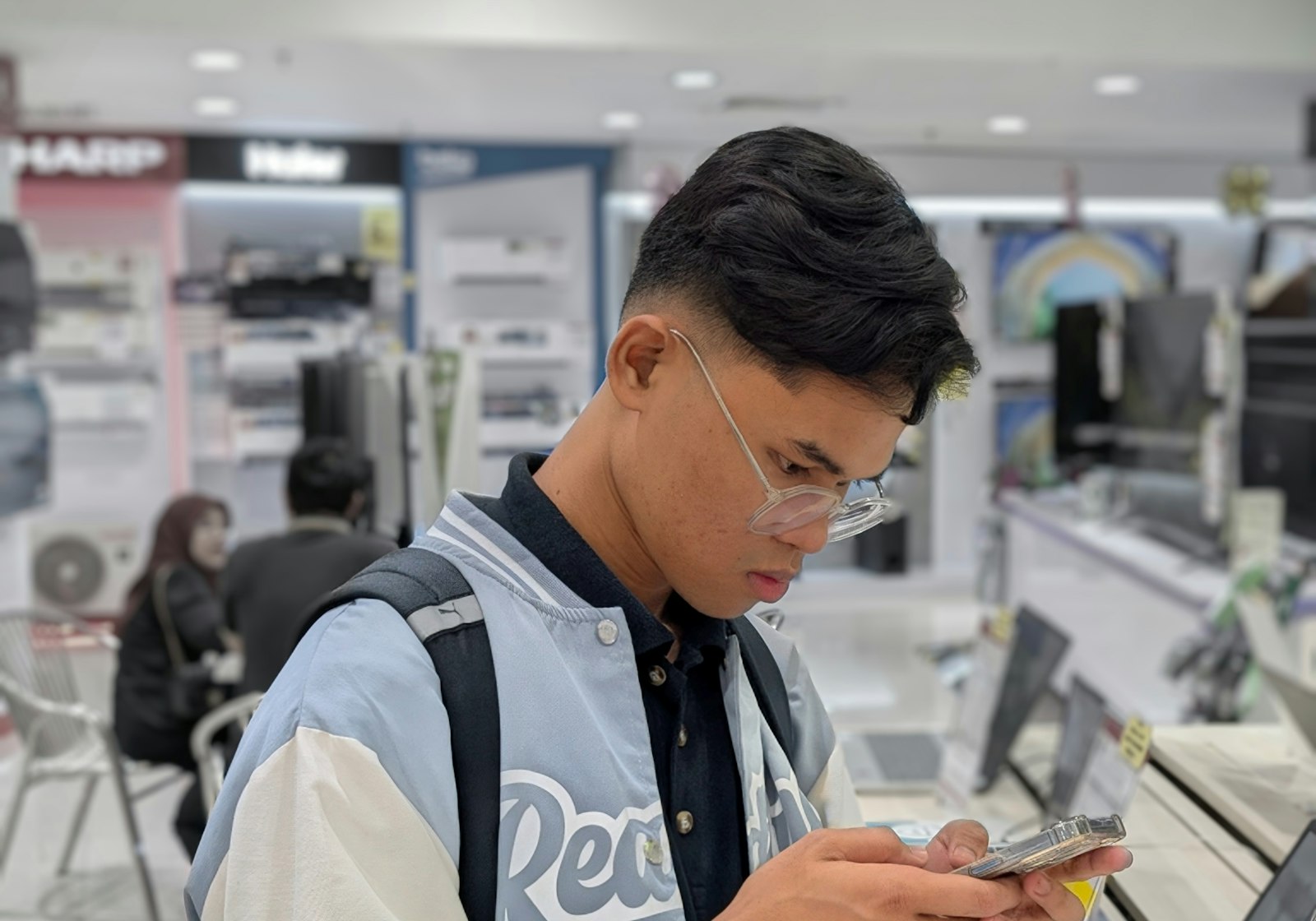 Klant in een telecomwinkel kijkt op zijn smartphone