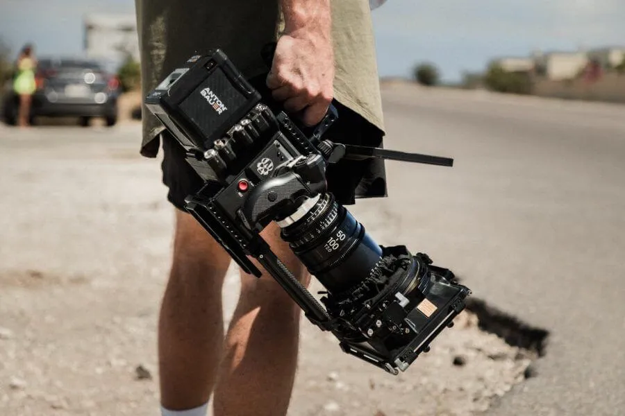 A man holding a camera on the side of a road