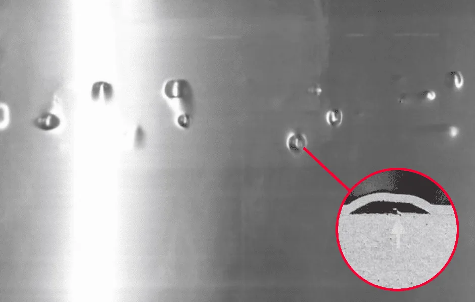 A metal surface with water drops on it