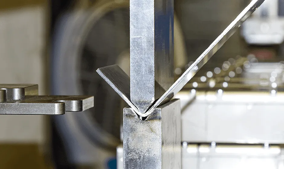 A close up of a metal object with a clock in the background