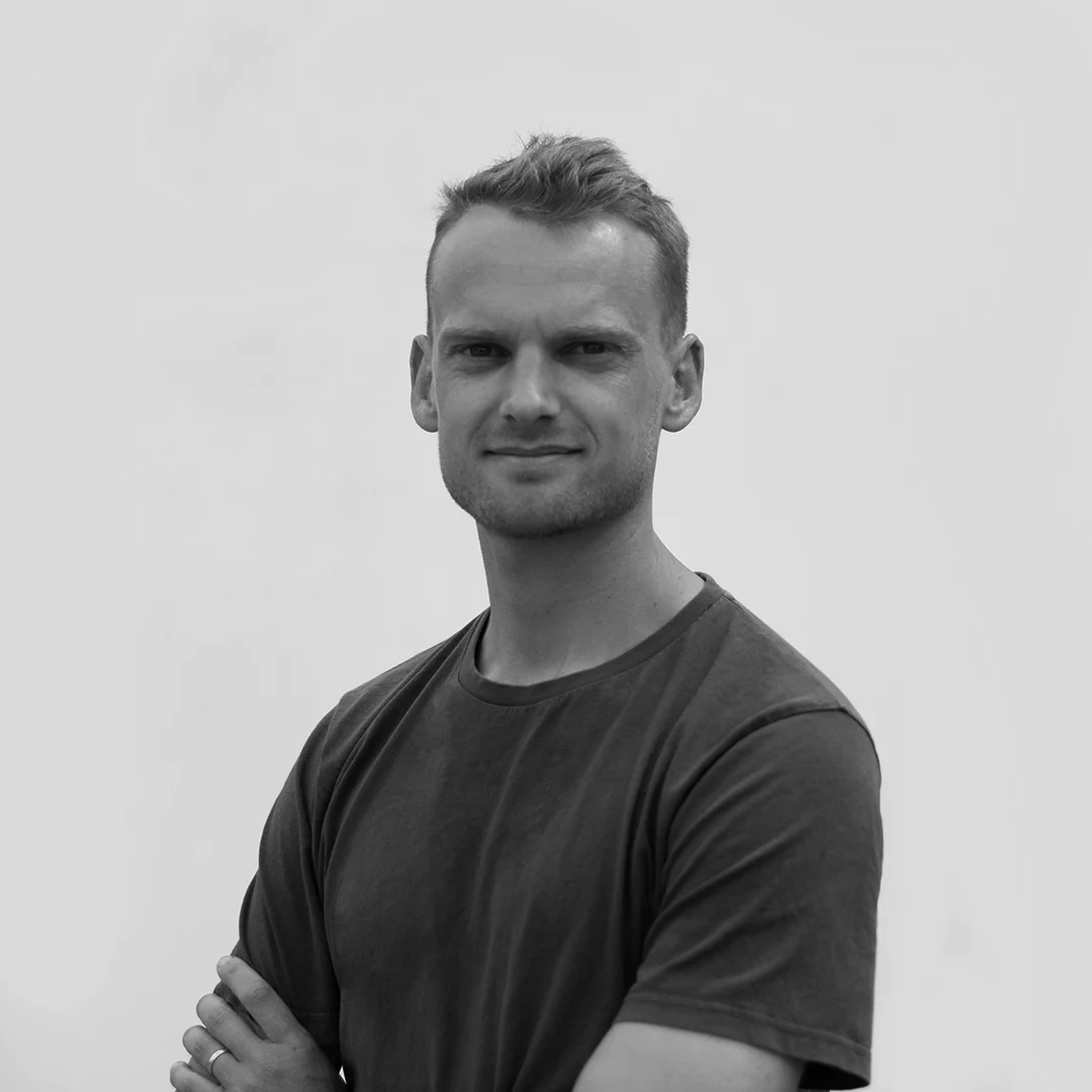 Black and white portrait of a smiling man in a dark t-shirt
