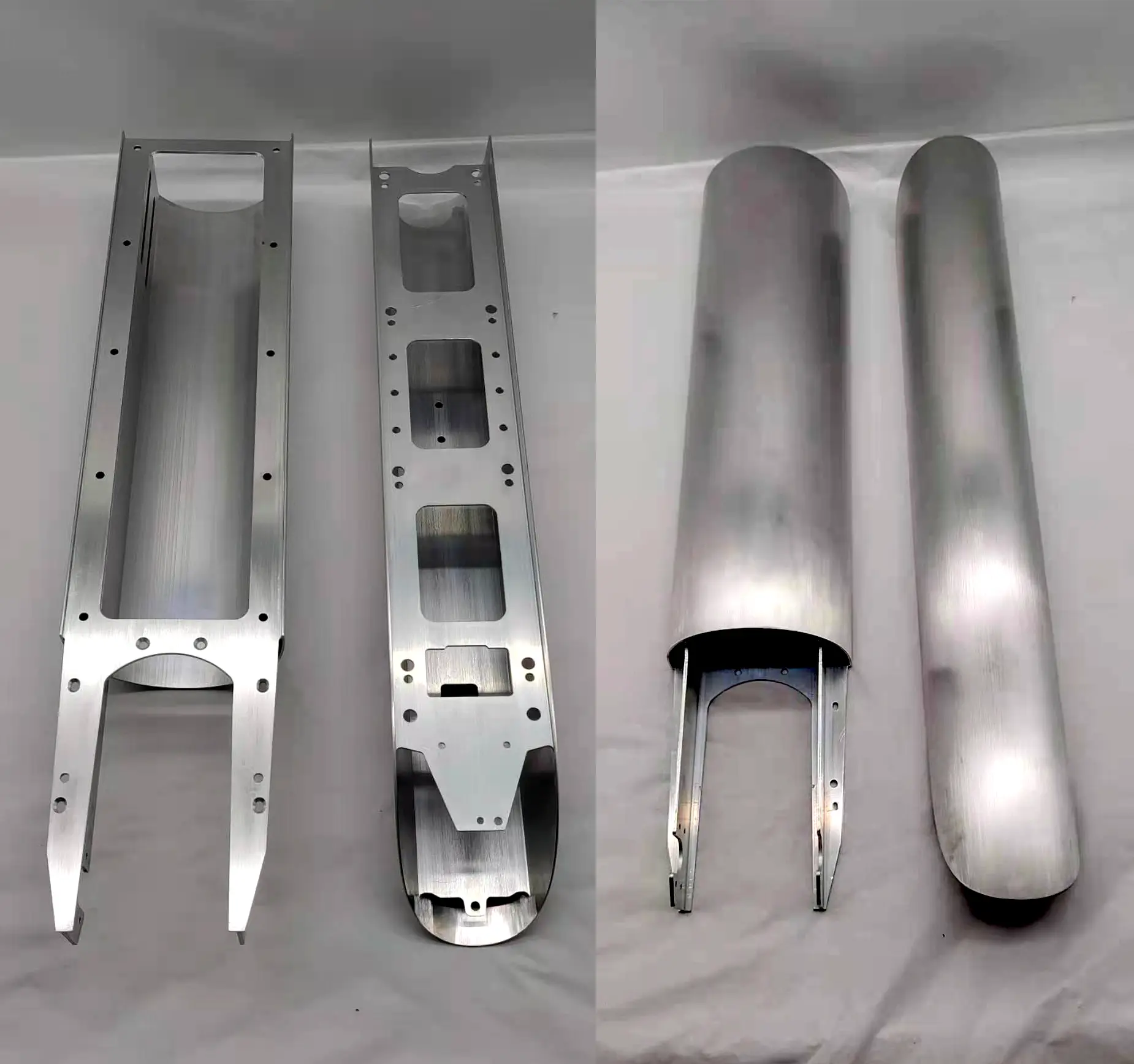 Metallic industrial components with complex geometric shapes and mounting holes