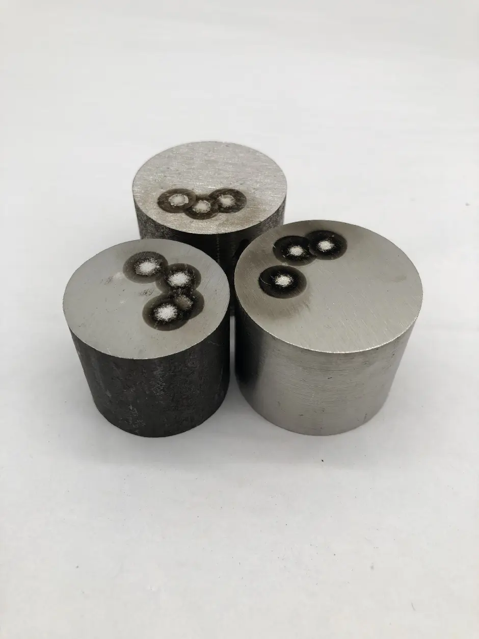 A group of three metal cylinders sitting on top of a white surface