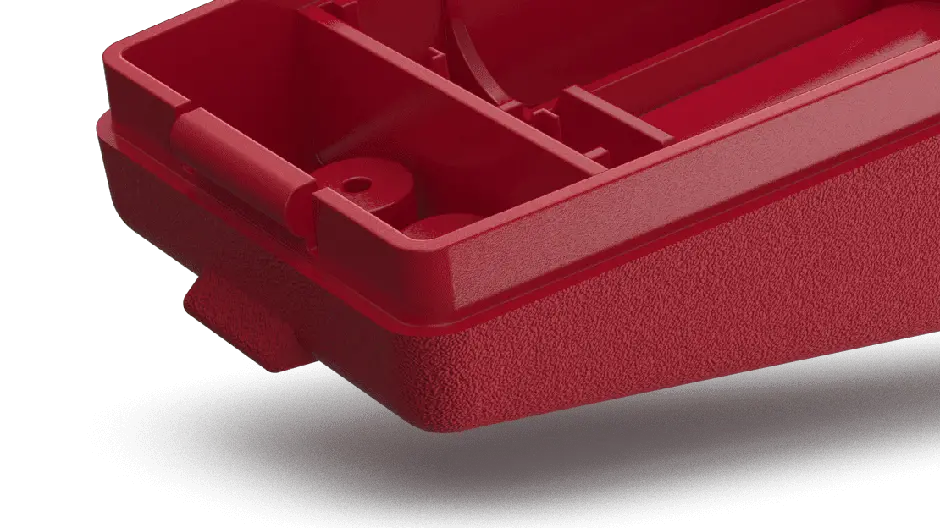 A red plastic box with a handle on a black surface
