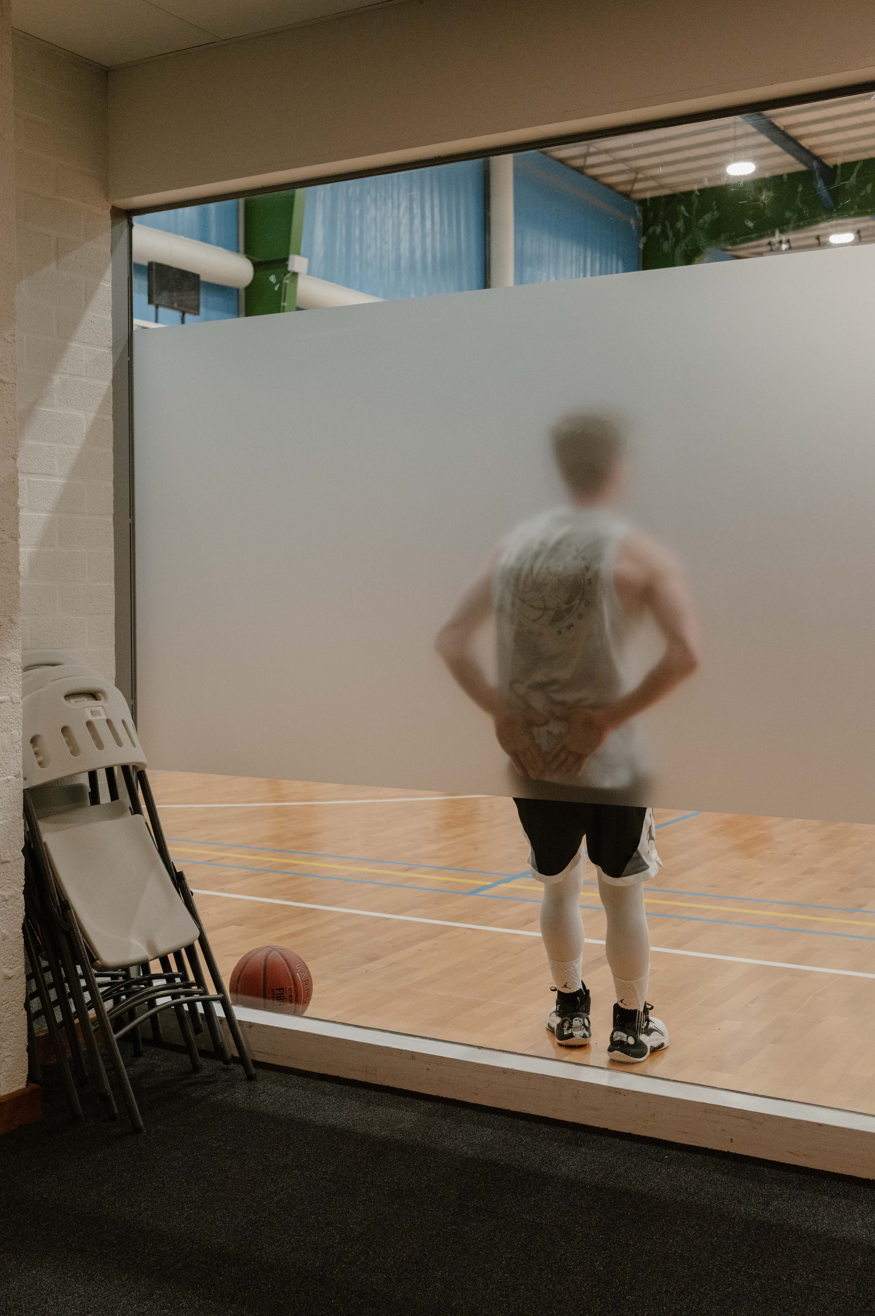 Een basketbalspeler rust even uit tijdens zijn training bij Apollo in Amsterdam. Basketbal voor de Volkskrant