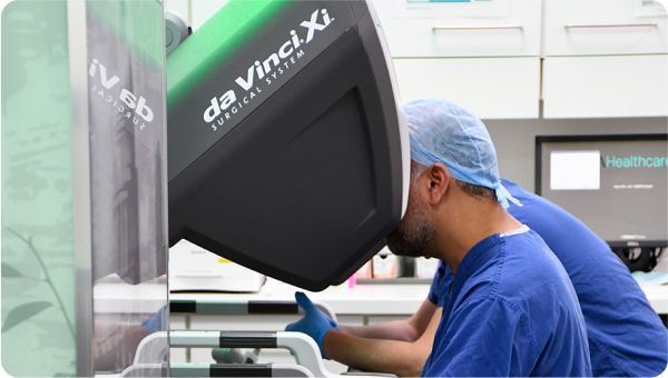 Mr Asit Arora, Head and neck surgeon, operating the da Vinci robot from the console while the robotic arms follow his directions