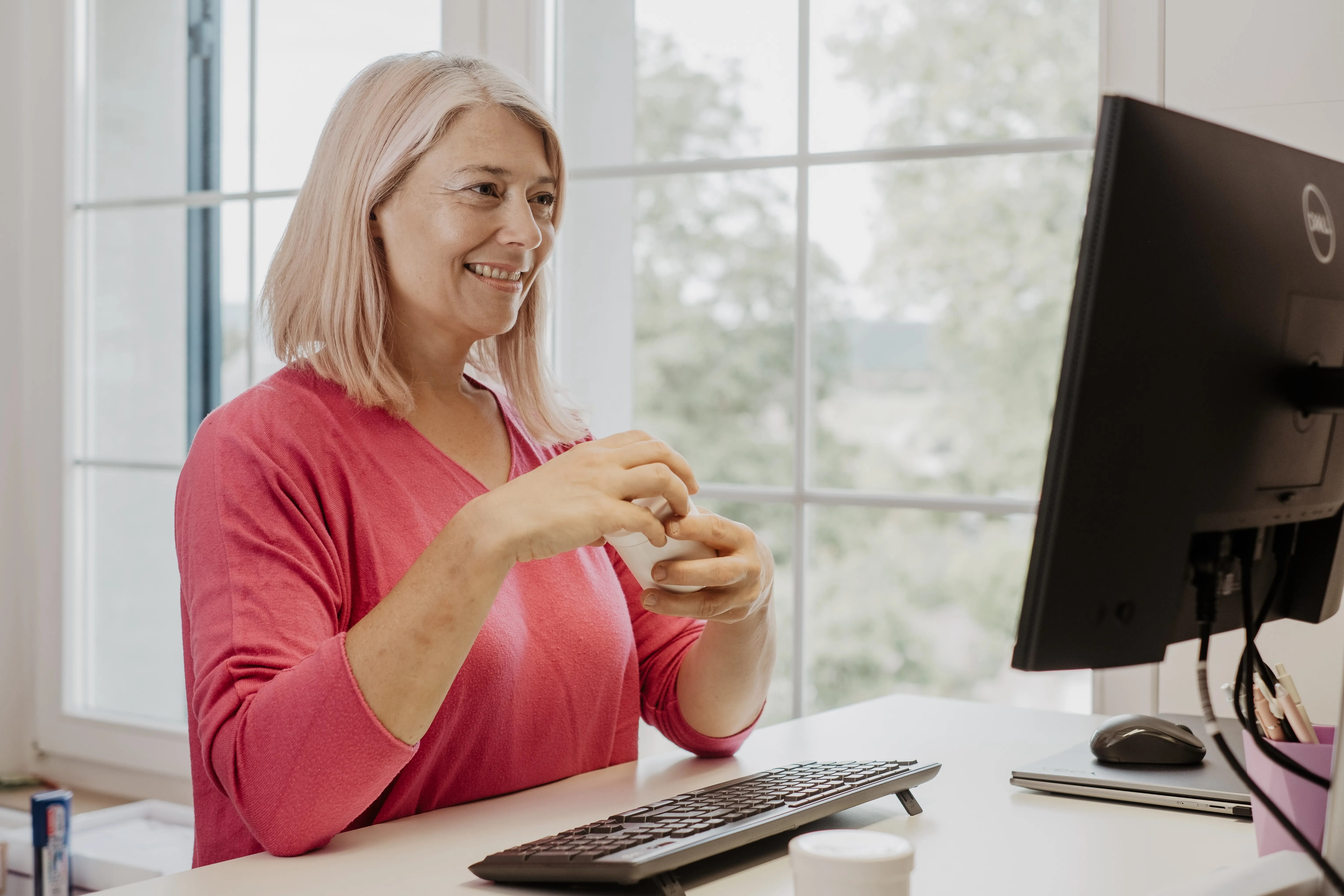 Judith Fiedler hat eine Probe in der Hand und ist in einem Online-Meeting vor dem Computer.