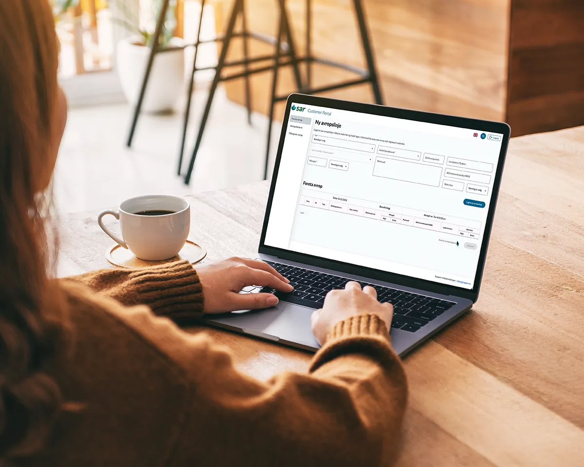 Person holder hendene på en laptop med kundeportalen på skjermen
