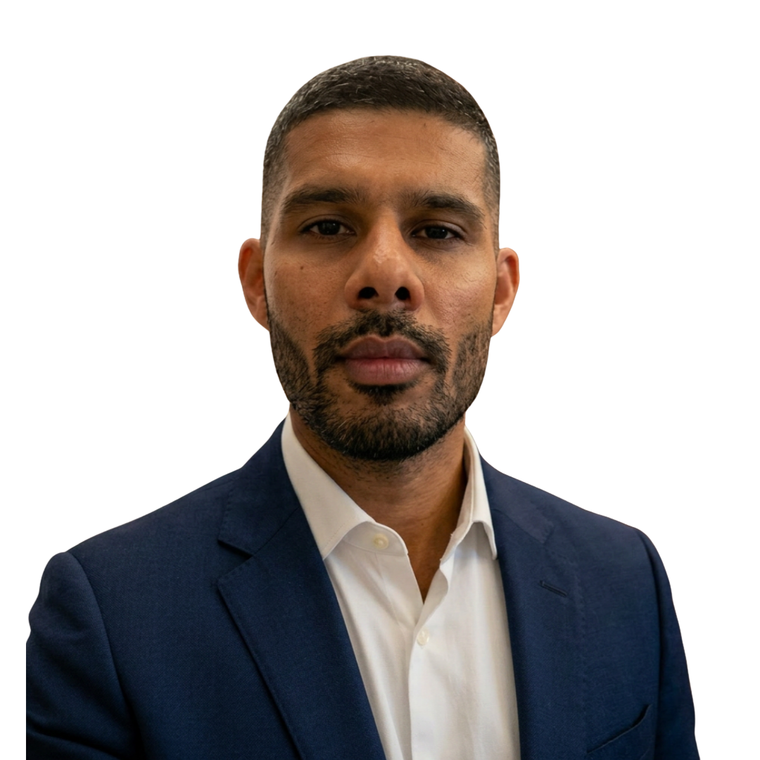 Man with short hair and beard wearing a white shirt and navy blue blazer against a transparent background.