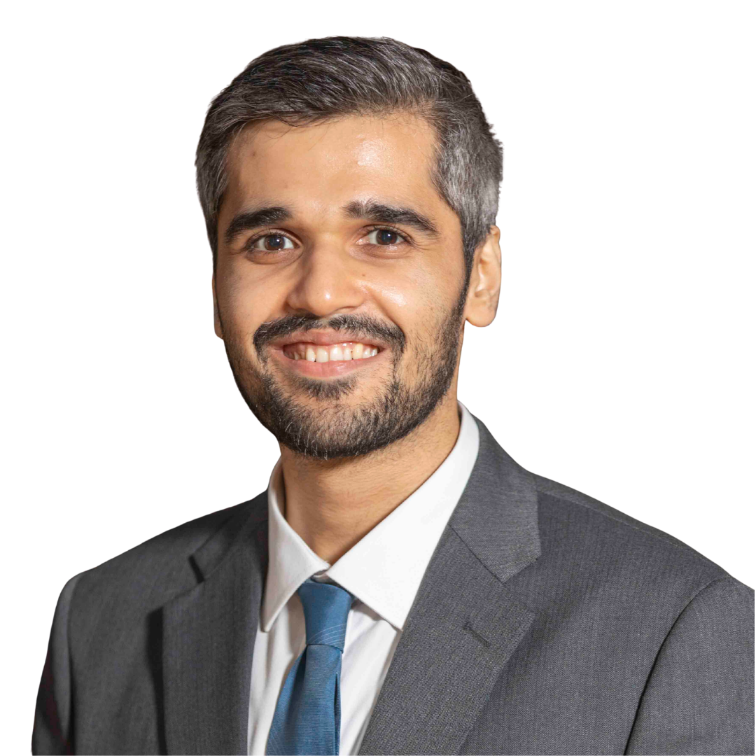 Smiling man with gray hair and beard wearing a gray suit, white shirt, and blue tie.