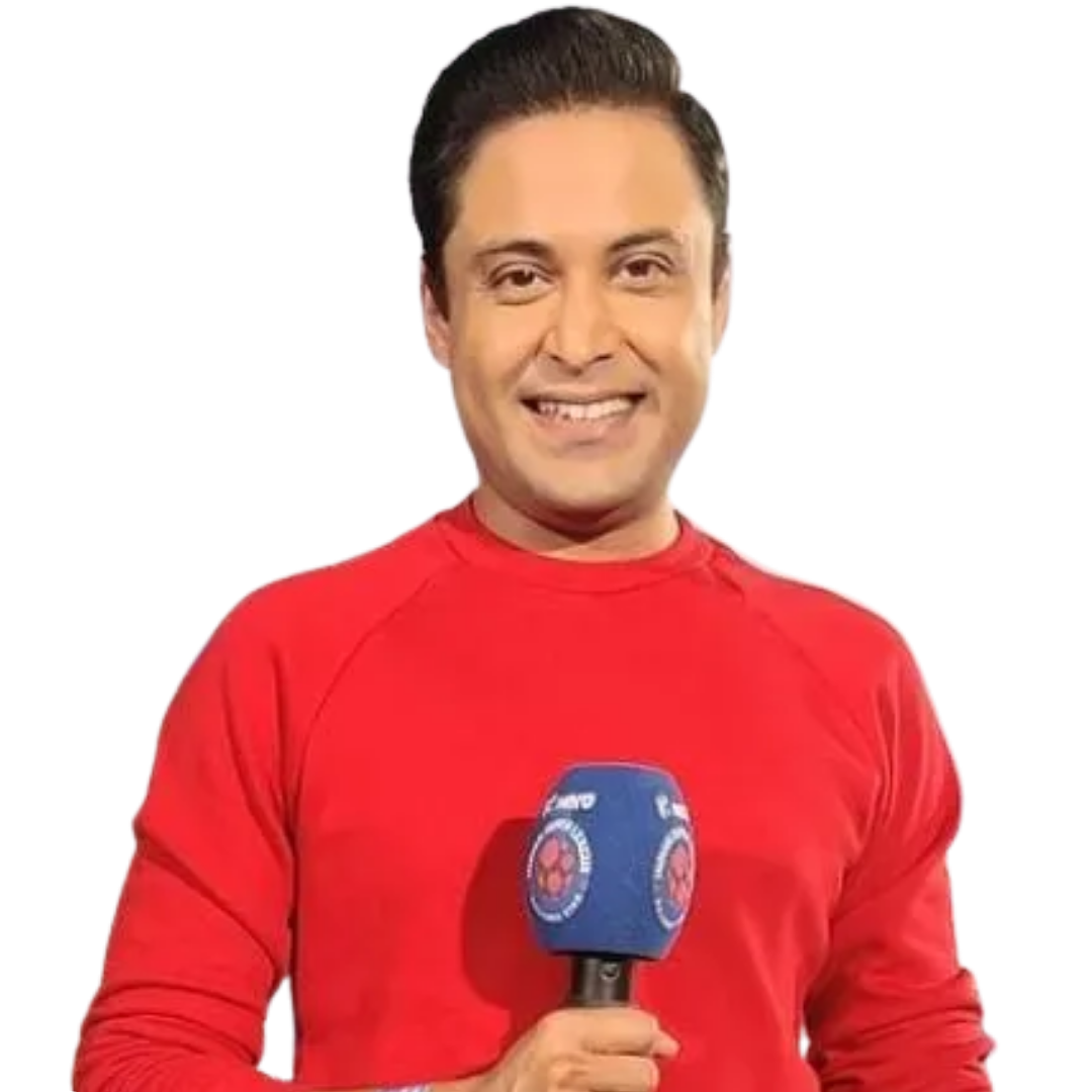Smiling man wearing a red long-sleeve shirt holding a microphone covered with a blue foam windscreen featuring a logo.