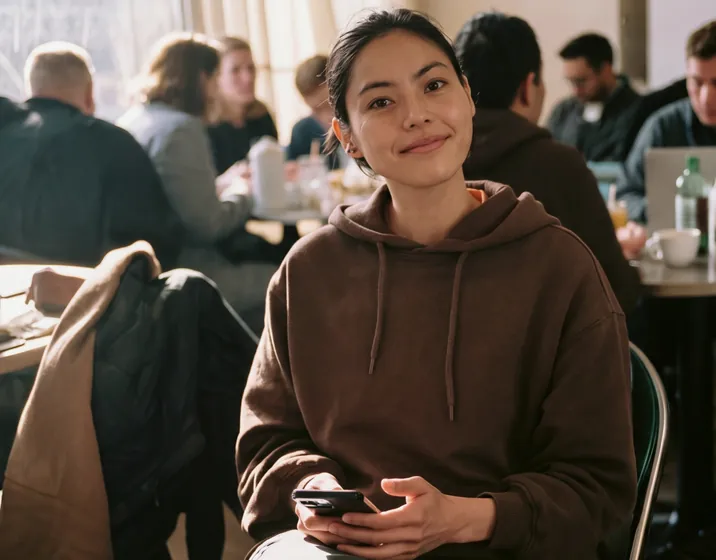 World Mobile customer using her phone in a café