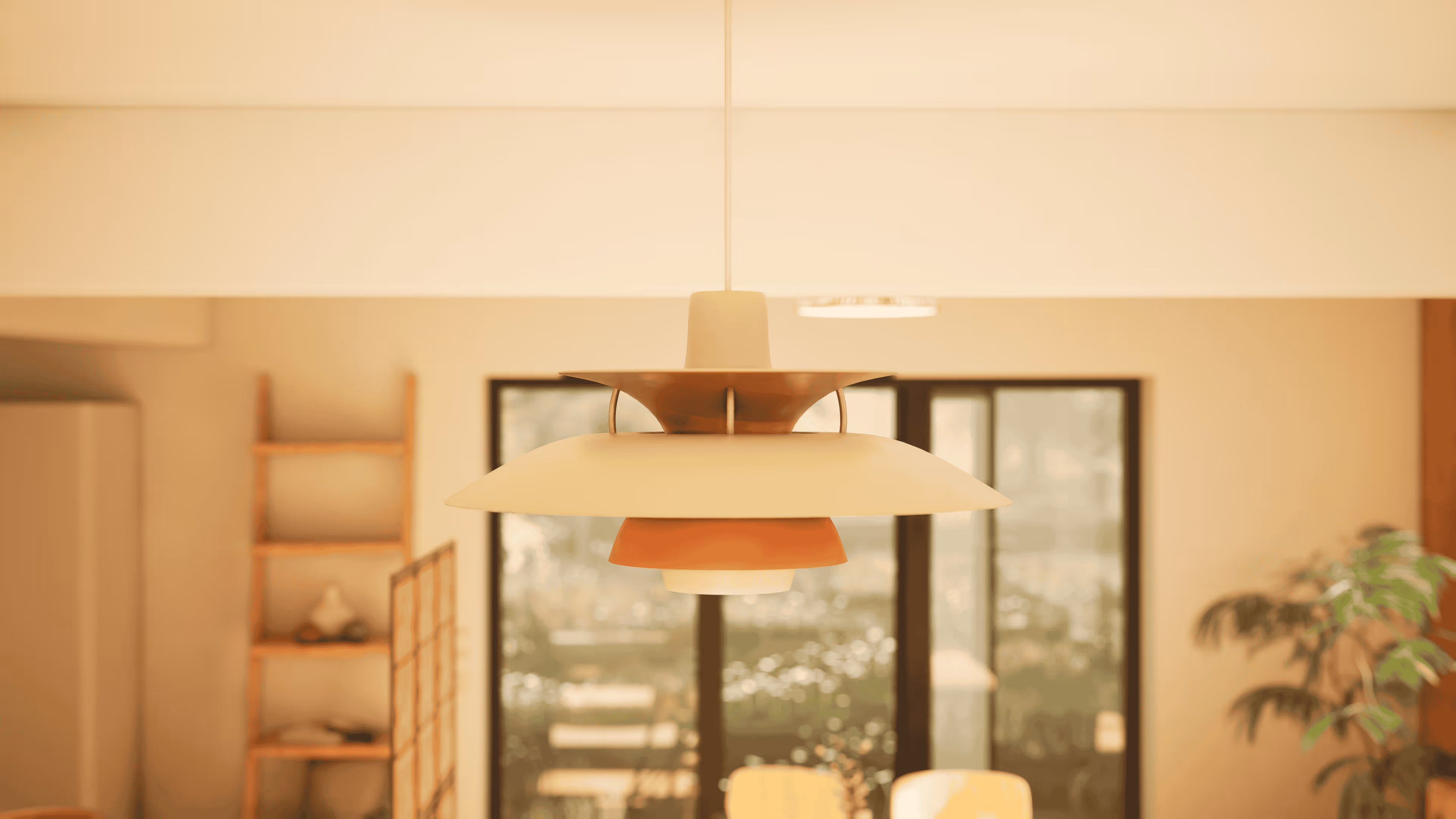 Modern pendant light fixture with layered shades hanging in a warmly lit room with a wooden shelf and large glass doors in the background.