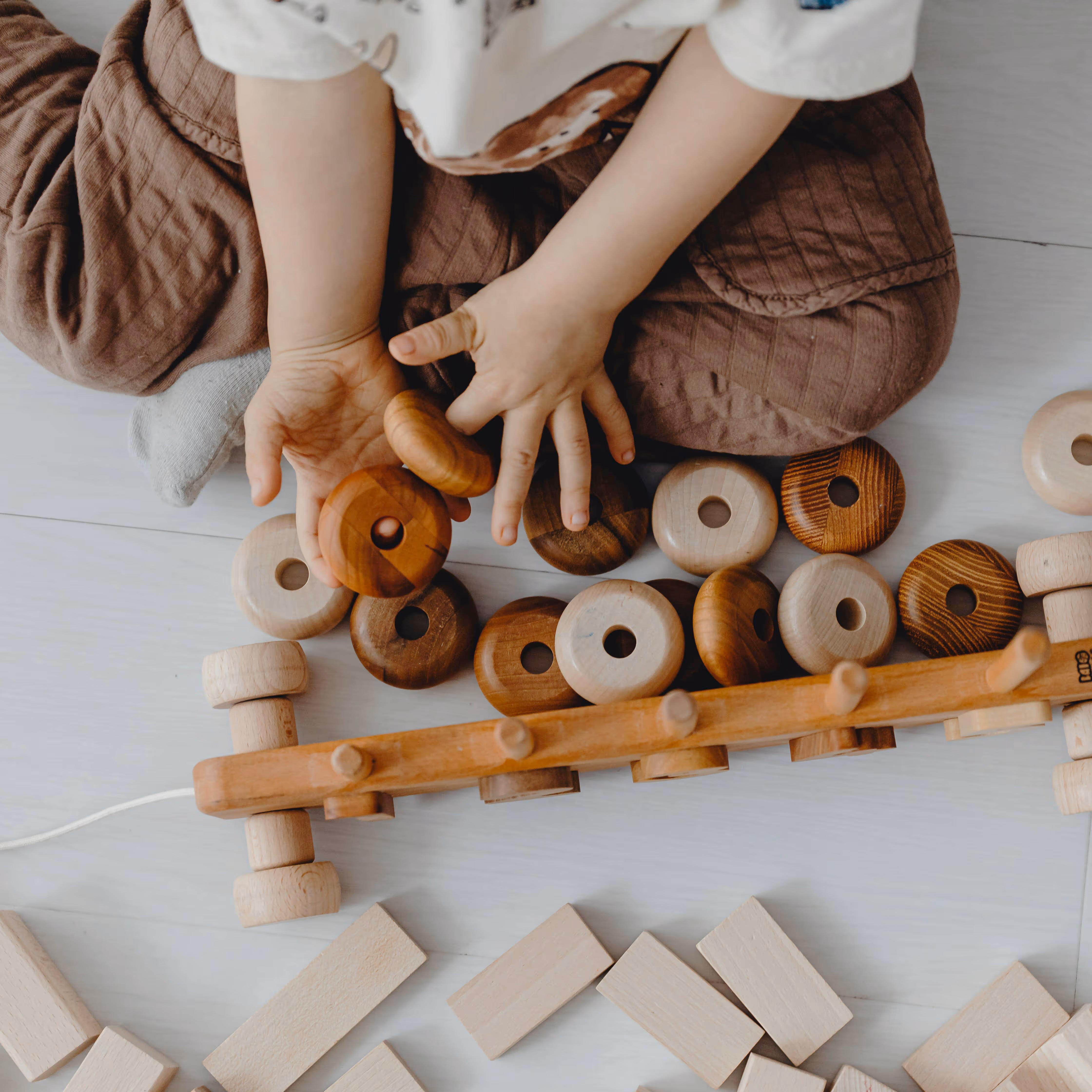 Dziecko bawi się drewnianymi klockami montessori